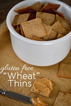 crackers and peanut butter in a bowl on a cutting board with the words gluten free wheat thins