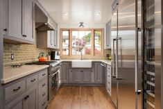 a kitchen with wooden floors and gray cabinets