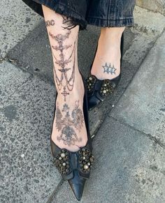 a woman's legs with tattoos and heels