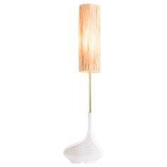 a white table lamp with a beige shade on the base and a gold - plated metal rod