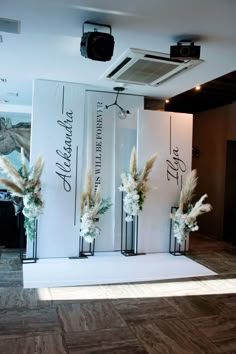 three tall vases with white flowers are on display in front of a video camera