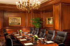 a conference room set up for a meeting with black leather chairs and wooden paneling