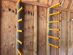 the inside of a building with wooden walls and ladders on it's sides