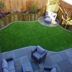 a small backyard with grass and seating area