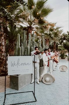 a group of men standing next to each other in front of a sign that says welcome