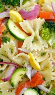 a pasta salad with broccoli, cucumbers and onions