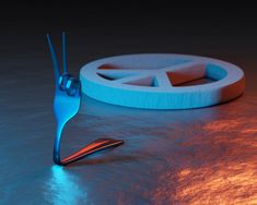 a blue object sitting on top of a table next to a piece of plastic material