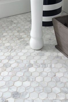 a white vase sitting on top of a bathroom floor next to a bathtub and sink