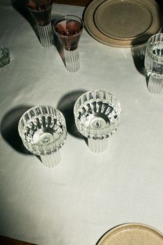 the table is set with dishes and glasses