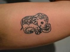 an elephant tattoo on the back of a woman's arm