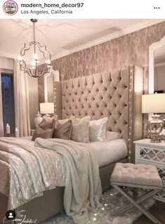 a bedroom with a large bed, mirrored nightstands and chandelier above it