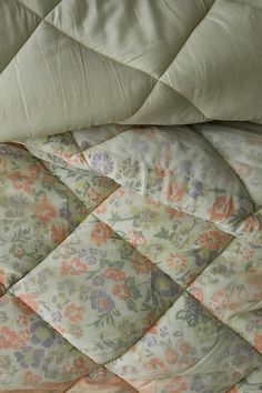 an unmade bed with floral comforter and pillows