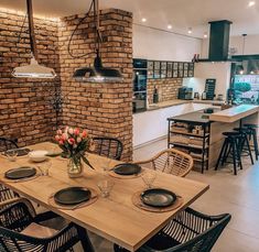 a dining room table and chairs in front of a brick wall with an oven on it