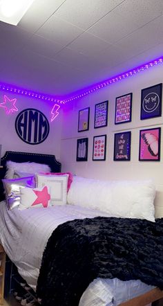 a bed room with a neatly made bed and purple lights on the wall above it