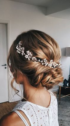 a woman with blonde hair wearing a white dress and a flower headpiece in her hair