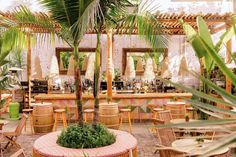 an outdoor restaurant with palm trees and wicker chairs