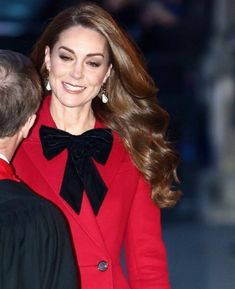 a woman in a red coat and black bow tie