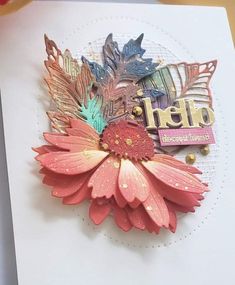 a close up of a card with flowers and leaves on the front, along with an embellishment that says happy