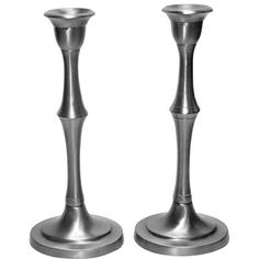 two metal candlesticks sitting on top of each other