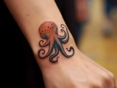 an octopus tattoo is on the wrist of a woman's arm and it looks like she has been tattooed