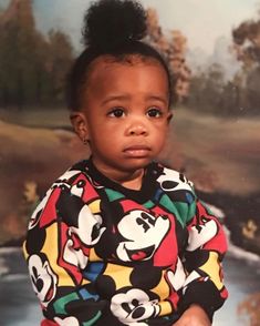 a young child wearing mickey mouse pajamas in front of a painting