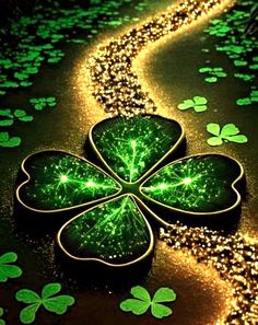 four leaf clovers are on the ground next to some gold and green sparkles