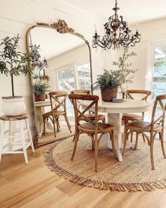 a dining room table with chairs and a large mirror on the wall next to it