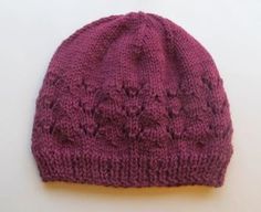 a purple knitted hat sitting on top of a white table