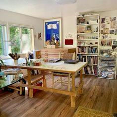 a living room filled with furniture and bookshelves next to a glass table covered in magazines