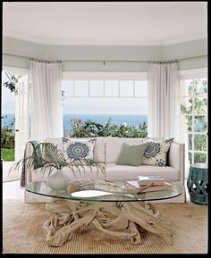 a living room filled with furniture and a glass top table in front of a window