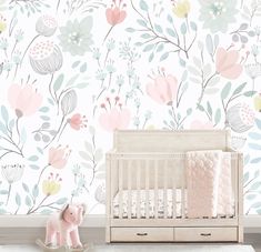 a baby's room with floral wallpaper and a crib in the foreground