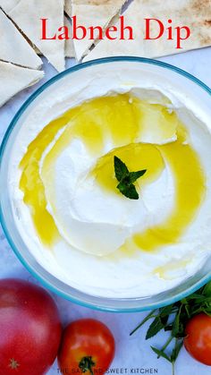 a bowl filled with whipped cream next to tomatoes