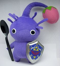 a purple stuffed animal holding a spoon and fork