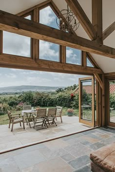 an open patio with table and chairs in the middle of it, looking out onto countryside