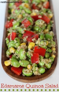 a wooden spoon filled with vegetables on top of a table