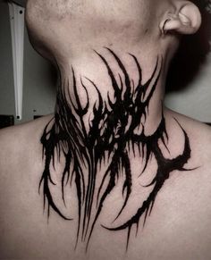 a man's neck is covered in black ink with an intricate design on it