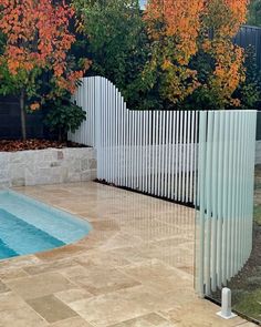 a white fence next to a swimming pool