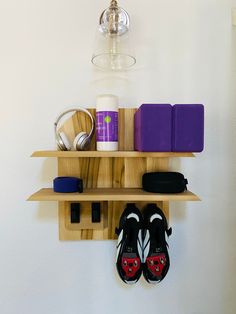 a pair of shoes hanging on a wooden shelf next to a wine glass and other items