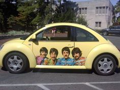 a yellow car with the beatles painted on it's side in a parking lot