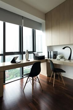 an office with wooden floors and large windows overlooking the cityscape is pictured in this image