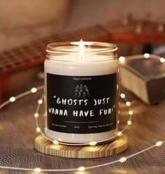 a white candle sitting on top of a wooden table next to a string of lights