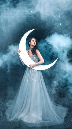 a woman in a long dress holding a paper moon