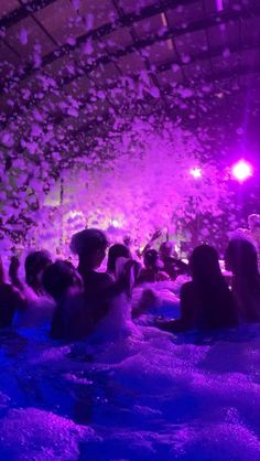 a group of people sitting in a swimming pool surrounded by confetti