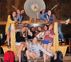 a group of young women posing for a photo in front of a large metal plate