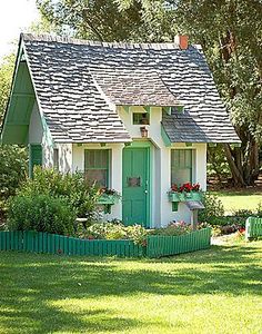 a green and white house sitting in the grass