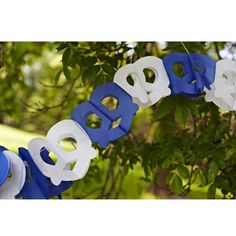 the word baby spelled out in white and blue plastic letters hanging from a tree branch