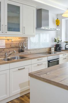 a kitchen with wooden counter tops and white cabinets