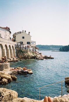 a person laying on the edge of a body of water