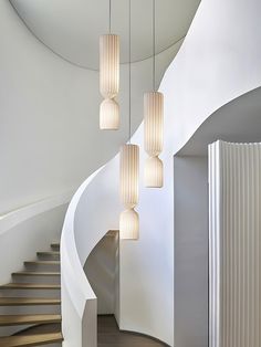 a spiral staircase with several lights hanging from it