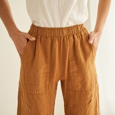 a woman wearing brown pants with her hands on her hips and the bottom half of her pants